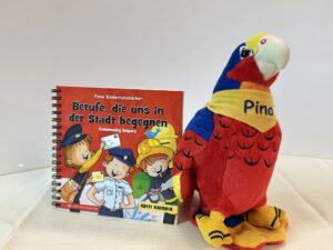 IMG_4008 Pinos zweisprachiges Kinderratebuch "Berufe die uns in der Stadt begegnen" + Pino der Papagei Plüschtier Bundle